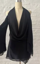 Vestido corto negro con escote halter, hombros descubiertos y mangas largas acampanadas.