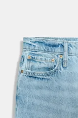 Jeans de tiro medio con cinco bolsillos, pernera recta y corte cropped. Cierre frontal con cremallera y botón.