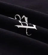Remera boxy negra de algodón con cuello V decorado con pequeñas estrellas bordadas y un bordado numérico en el centro del pecho.