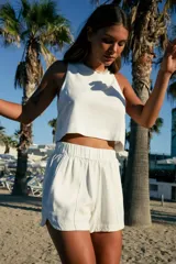 Short blanco de lino y rayón con cintura elástica y bolsillos laterales.