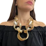Collar corto con eslabones grandes de resina color beige y blanco. Cierre con mosquetón y cadena para regular el largo.