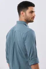 Camisa de lino de manga larga en color beige, con cuello camisero, cierre frontal de botones y un bolsillo ojal en el pecho.