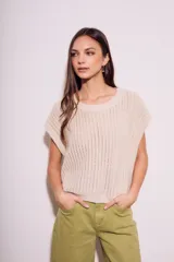 Chaleco sin mangas de tejido de punto color rosado pálido, con textura calada y acabado lurex, corte al cuerpo y cuello redondo.