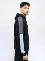 Canguro negro con capucha, corte clásico, mangas largas con franjas grises y logo de la marca bordado en el pecho.