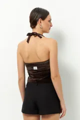 Top negro de terciopelo con escote halter, sin mangas y espalda descubierta.