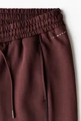 Pantalón de jogging deportivo de corte holgado, confeccionado en tejido funcional con tecnología DryMove™ que absorbe el sudor. Presenta cintura elástica con cordón de ajuste, bolsillos laterales, ribetes verticales en las piernas y bajos ajustables con cordón elástico.