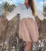 Vestido corto con parte superior blanca abotonada y parte inferior color durazno con botones.