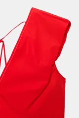 Top rojo de popelín con escote en V pronunciado, mangas sisa y pespuntes en contraste. Cuenta con tirantes finos cruzados y lazada en la espalda.