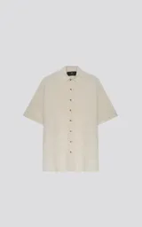 Camisa de manga corta color blanco roto, con cuello clásico y cierre frontal de botones.