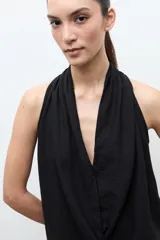 Blusa sin mangas de lino color maíz, con cuello drapeado y diseño fluido.