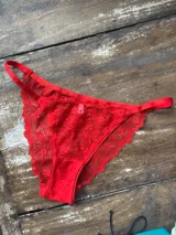 Bombacha roja de encaje con elásticos al costado.