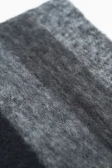 Bufanda de lana con diseño de bloques de color en tonos negro y gris.