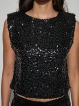 Top de lentejuelas negro sin mangas, corte recto y corto tipo crop top.