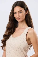 Musculosa de algodón color beige con delicado estampado floreado, escote redondo y pequeños volados en las sisas.