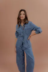 Chaqueta de jean azul, de corte entallado, con cuello camisero, cierre frontal con botones y bolsillos delanteros con solapa.