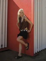 Falda corta negra con efecto globo (balloon) y volados en el ruedo. Se ajusta a la cintura con un cinturón de estilo western con hebilla grande y detalles en blanco y negro.