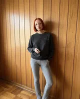 Buzo de cuello redondo con efecto stone wash, confeccionado en tejido de algodón y poliéster con interior de felpa. Presenta un corte regular, puños y cintura acanalados, y el logo de la marca estampado en el pecho.