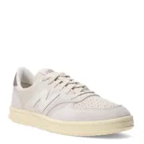 Championes urbanos New Balance modelo Court, color beige con detalles en crema y suela de goma con efecto envejecido. Presentan el logo N característico en los laterales y perforaciones en la puntera para mayor ventilación.