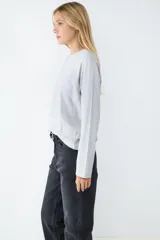 Remera básica de manga larga color gris melange, con cuello redondo y corte regular. Confeccionada en tejido de punto liso de algodón.