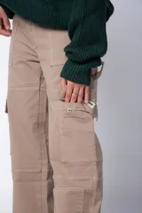 Pantalón tipo carpintero de corte relaxed fit y tiro medio, confeccionado en denim negro con costuras a contracolor en blanco. Presenta múltiples bolsillos cargo laterales, un bolsillo con cierre en la parte inferior y presillas utilitarias.