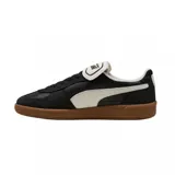 Championes Puma modelo Palermo, con diseño de perfil bajo en color negro con detalles en blanco y suela de goma color caramelo. Presentan el logo de la marca en dorado en el lateral y una lengüeta distintiva.