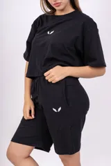 Bermuda negra de corte holgado con cintura elastizada y logo estampado en blanco en la pierna izquierda.