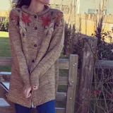 Cárdigan marrón de lana merino con botones al frente y flores bordadas.