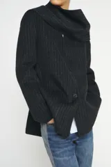 Blazer de corte recto confeccionado en mezcla de lana con estampado de rayas verticales. Presenta cuello redondo con bufanda incorporada en el mismo tejido, manga larga, bolsillos delanteros y cierre frontal con botones.