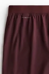 Short deportivo bordó fabricado en tejido funcional con tecnología DryMove, cintura elástica con cordón ajustable oculto y aberturas laterales en el bajo.