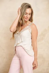 Musculosa de seda color champagne, con escote en V decorado con encaje delicado y tirantes finos.