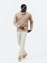 Polo manga larga color beige en tejido piqué, corte regular, con cuello clásico y tapeta de dos botones.