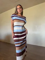 Vestido midi de punto de algodón con diseño a rayas horizontales en tonos celestes, tostados, blancos y bordó, de corte recto, manga caída y escote redondo.