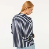 Blusa de corte fluido y holgado con estampado de rayas verticales en azul marino y blanco. Presenta cuello camisero clásico, cierre frontal con botones y mangas largas con puños abotonados.