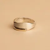 Anillo de diseño ancho con banda central de textura satinada y bordes pulidos en contraste. Combinación de plata 925 y oro.