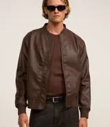 Campera estilo bomber de poliuretano color marrón, con cierre frontal de cremallera, cuello, puños y dobladillo acanalados.