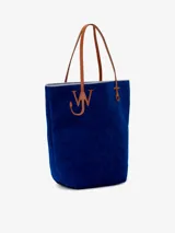 Bolso tipo tote de chenilla color verde oscuro con ribete amarillo. Tiene dos correas de hombro color crema, compartimento principal con bolsillos internos y apliques metálicos con el logo de la marca.