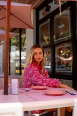 Camisa de manga larga con diseño abullonado, confeccionada en tela bordada con motivos florales. Presenta cierre frontal con botones y puños elásticos.