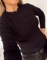 Remera de morley color mostaza, de manga larga, con cuello alto fruncido y terminaciones fruncidas en las mangas.