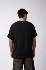 Remera de corte regular confeccionada en una mezcla de rayón y lino con textura entramada. Presenta cuello redondo, mangas cortas y un diseño de inspiración rústica y liviana.