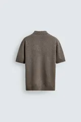 Polo de punto de algodón con corte regular, cuello solapa y cierre frontal de cremallera. Presenta manga corta y acabados en rib.