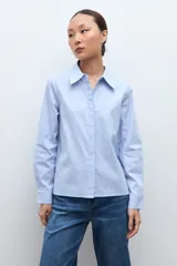 Camisa de manga larga color celeste, con cuello clásico y botones frontales.