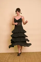 Pollera midi negra de corte acampanado con múltiples volantes escalonados y cintura elástica.