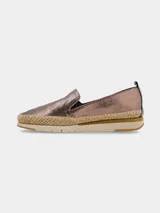 Zapatilla slip on de mujer, color cobre metalizado con efecto craquelado. Presenta una plataforma con suela de goma y una banda de yute trenzado alrededor de la base, estilo alpargata.