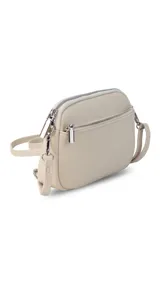 Bandolera pequeña de diseño rectangular en color beige, confeccionada en cuero sintético. Presenta una correa larga ajustable del mismo material y cierre superior con cremallera. Incluye el logo de la marca grabado en la parte frontal.