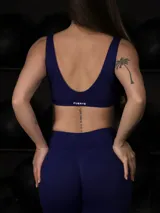 Conjunto deportivo sin costuras color azul, compuesto por un top deportivo con escote en V y espalda descubierta con copas removibles, y una calza larga con control de abdomen y realce de glúteos.