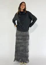 Sweater de punto color beige con cuello alto, diseño de rombos en relieve y detalle de lentejuelas aplicadas en el frente.