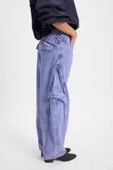 Jean de corte baggy con pierna recta y ancha, color verde oscuro con efecto lavado. Presenta bolsillos cargo laterales, costuras reforzadas y detalle de bordado del isologo en la parte trasera.