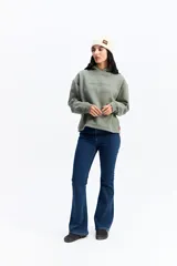 Canguro de algodón color verde oliva, con capucha amplia, corte relajado y estampa frontal con texto. Presenta un diseño sin rib en los puños y ruedo.