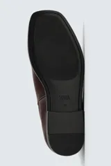 Bota estilo Chelsea de cuero negro, con elásticos laterales y suela plana a tono con ligero tacón.