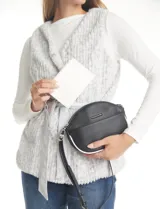 Cartera tipo bandolera de eco cuero con silueta de media luna, color beige y detalles en marrón claro. Incluye un monedero/tarjetero independiente en el bolsillo frontal y una cadena decorativa de eslabones dorados.